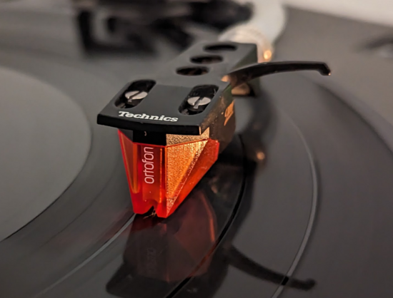 The business end of a tonearm sitting in a groove.