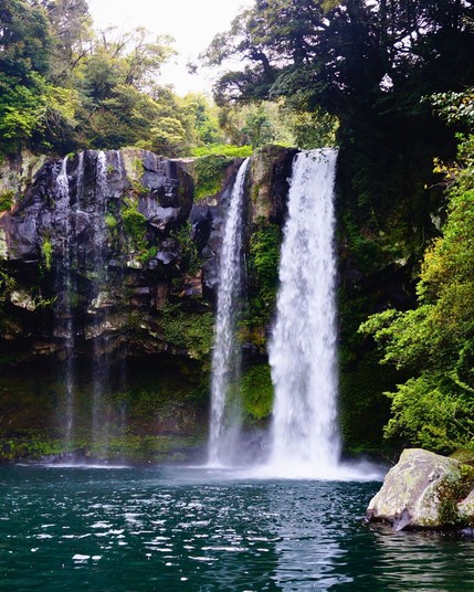 Cheonjiyeon Falls in South Korea is known as the Pond of God and is surrounded by lush, tropical vegetation, creating a serene and otherworldly atmosphere.