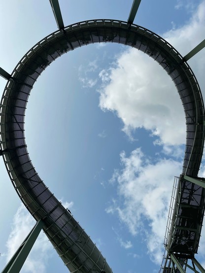 Photo looking straight up at the first turn of Bobbahn. The train is just visible through the track halfway round the turn.