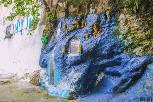 Our Lady of Aparecida ("Our Lady revealed"), (Portuguese: Nossa Senhora Aparecida or Portuguese: Nossa Senhora da Conceição Aparecida) painted on a prominent rock coming out from a hillside in Gloria, Rio de Janeiro. The rock is painted blue and golden Catholic saints and Christ statues painted in gold are accompanying the Virgin.