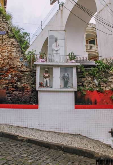The Sanctuary of Zé Pelintra and Maria Navalha in a glass cabinet on the street that goes up the hill of Santa Teresa, on the left side of the Lapa arches.