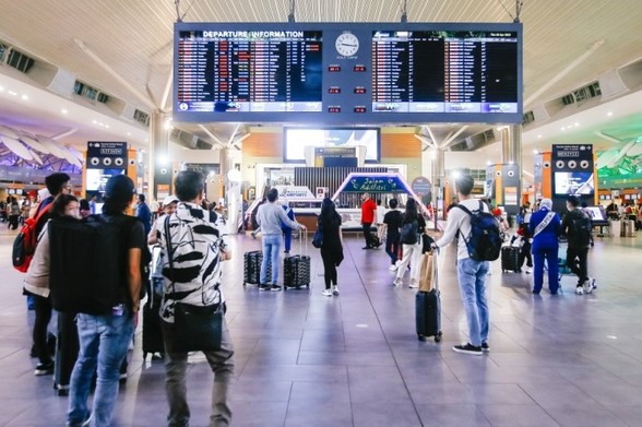 People inside an airport terminal. / Photo from the linked article.