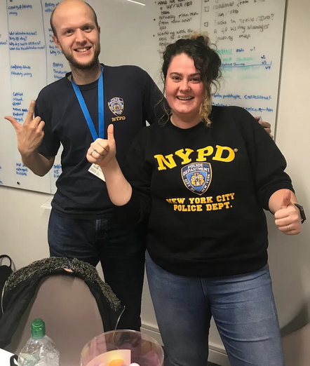 Man and woman, both smiling wearing NYPD tops