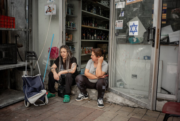 Mofeda discute avec une de ses clientes devant son échoppe à Sderot, dimanche 29 octobre 2023. © Photo Thomas Dévényi / Hans Lucas pour Mediapart