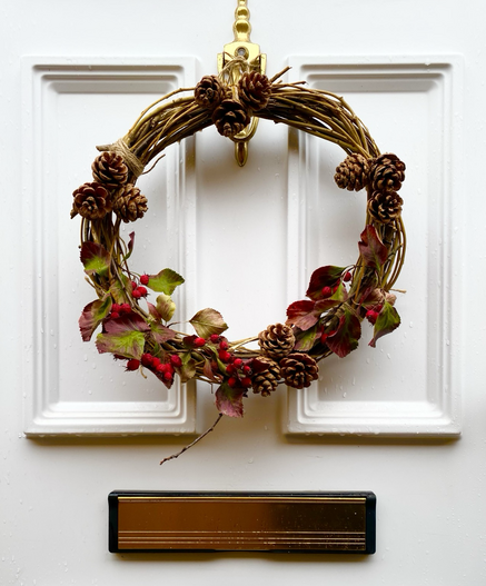 Autumn wreath hanging on door. Browns, reds, greens