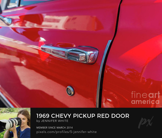 A closeup photo of the door handle of a red 1969 Chevy Pickup Truck