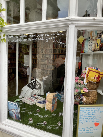 View into all-volunteer bookshop in South Queensferry Scotland. Volunteer is reading. 