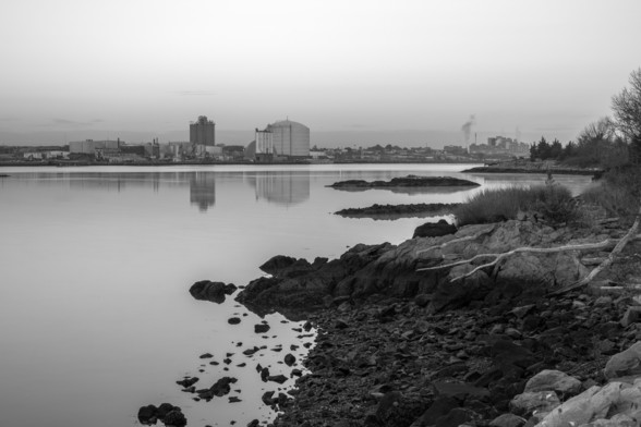 Mist on the water just visible by the rocky islands in black and white