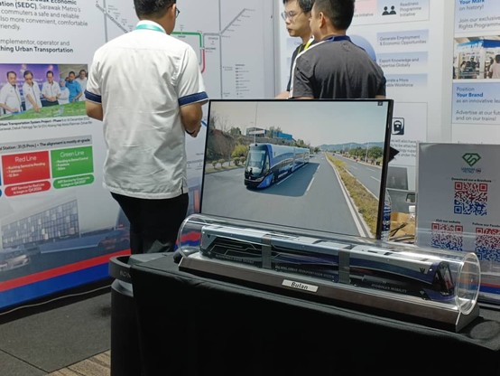 A screen showing video of ART vehicle as well as a replica of the vehicle on a table.