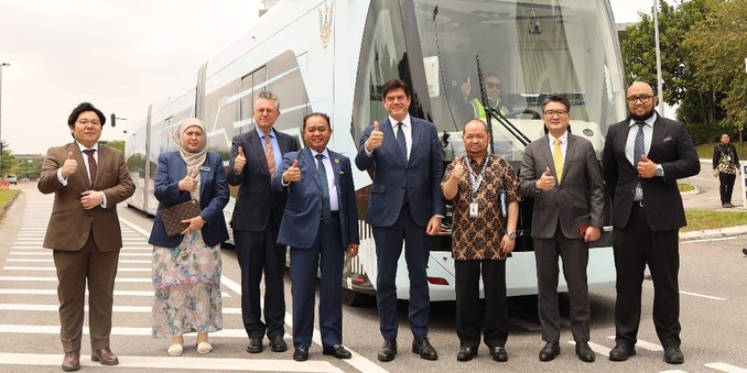 A group of people in front of Autonomous Rapid Transit vehicle.