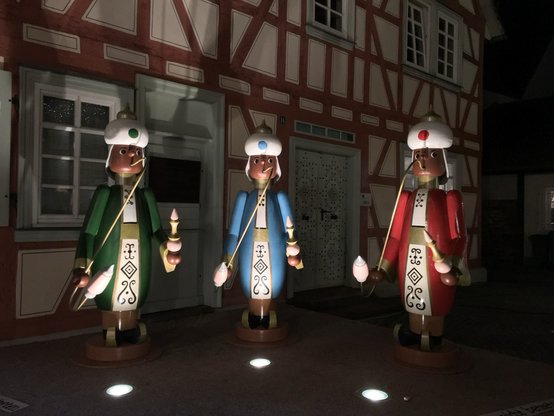 Die heiligen Drei Könige als bunter Holzfiguren vor einem Fachwerkhaus