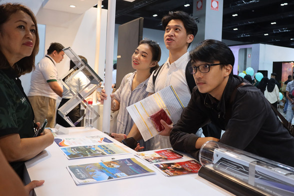 People at a booth looking at something.