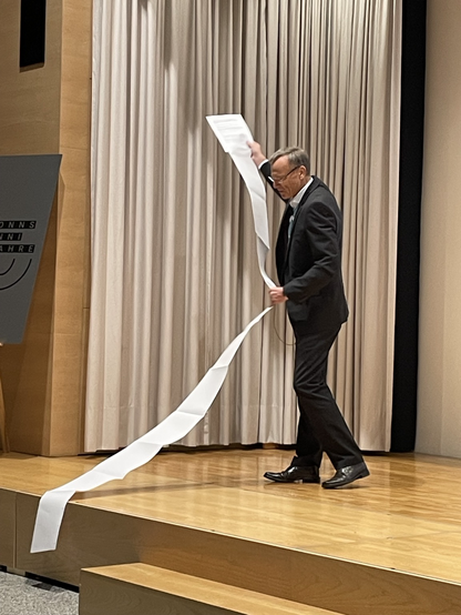 Wolfgang Semar auf der isi2023 mit der ausgedruckten Publikationsliste von Rainer Kuhlen 
