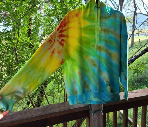 A hoodie dyed in radiating rainbow colors, starting with red in the shoulder and moving down to blue at the hem. 