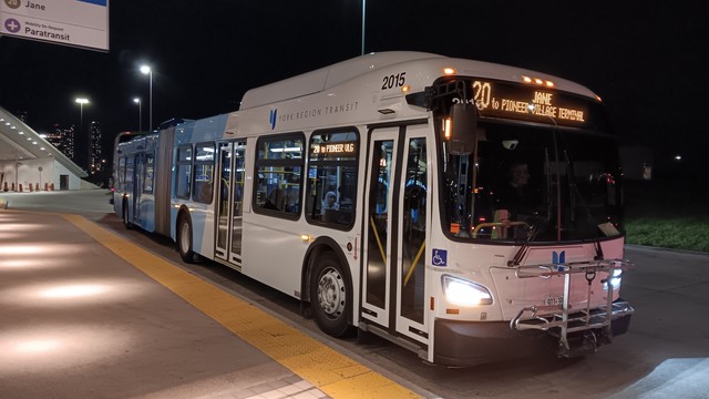 York Region Transit 2015, a New Flyer XD60 bus. The front sign reads "20 JANE to PIONEER VILLAGE TERMINAL", and the right side sign reads "20 to PIONEER VLG". The bus has the regular YRT local livery.