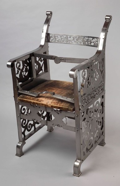 Silla metálica adornada, con asiento de cuero y sujeciones.