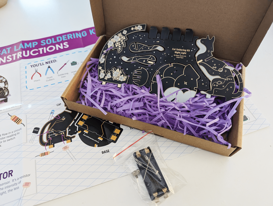 The cat soldering kit unboxed, showing the snap-out circuit board, full colour A3 instructions and parts.  