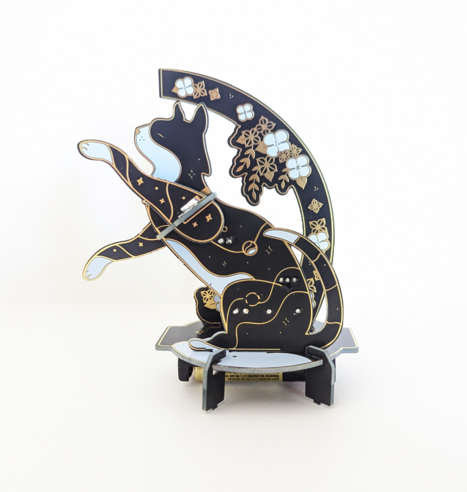 A soldering kit featuring a black, gold and white cat.  When assembled, it's a night light that turns on when it gets dark. 