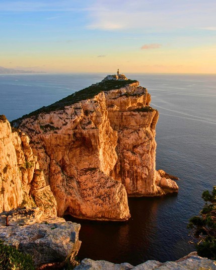Capo Caccia, situated on the Sardinian coast, is a striking limestone promontory known for its dramatic cliffs, sea caves, and the famous Neptune's Grotto.