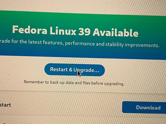 A screenshot of the Fedora Software application with the mouse cursor hovering over the Restart and Upgrade button to upgrade to Fedora Linux 39.