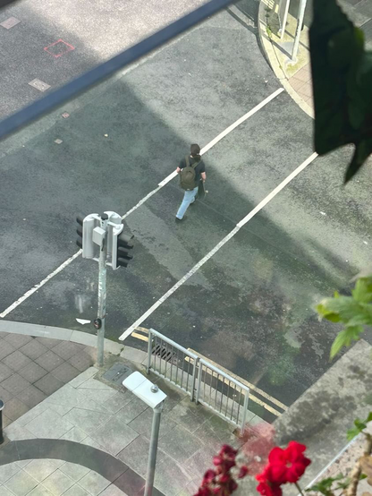 Man walking across road with skateboard 