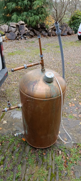 A smaller and much older bare copper hot water cylinder. There are signs it has been leaking a little over time.