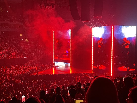 Doja Cat on stage, which is bathed in bright red light