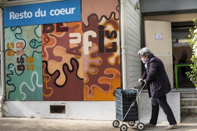 Une femme agée sort des Restos du Cœur, à la Courneuve, le 17 avril 2020. © Photo Marta Nascimento / REA