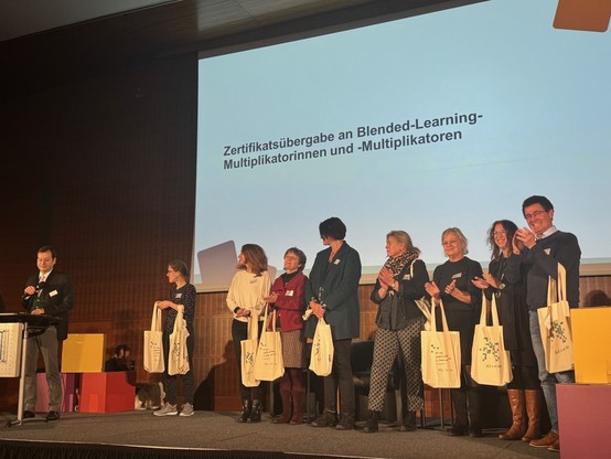 Zertifikatsübergabe auf der Bühne an 8 Personen 