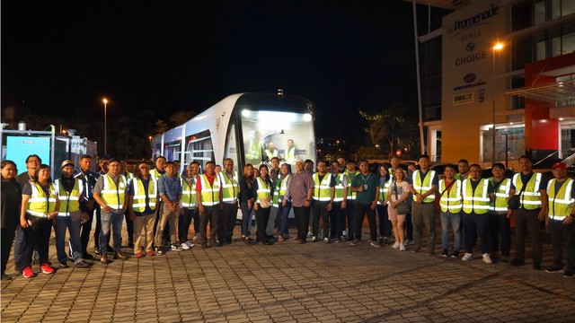 A group of people in front of the ART vehicle.