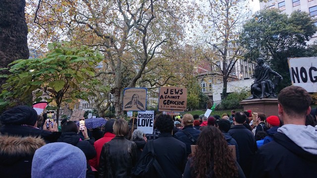 Photo of Na'amod protestors in Victoria Gardens. Signs include "Jews against Genocide", "Choose Love", "No Genocide", "Jewish Diaspora says no arms to Israel ".