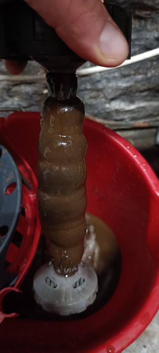 A magnetic filter caked with rusty sludge after 2 hours