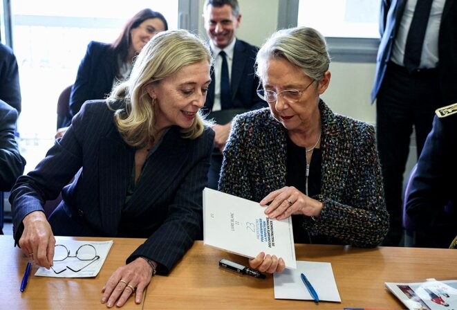 Elisabeth Borne et la secrétaire d'État française chargée de l'Enfance, Charlotte Caubel dans ‘les locaux de l’association d'aide aux victimes « L’Enfant Bleu » à Issy- les-Moulineaux, le 20 novembre 2023. © Photo Alain Jocard / AFP