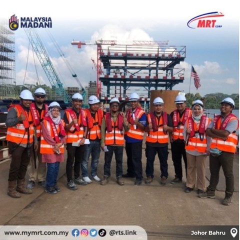 A group of people at the construction site of the RTS Link viaduct's pillar.