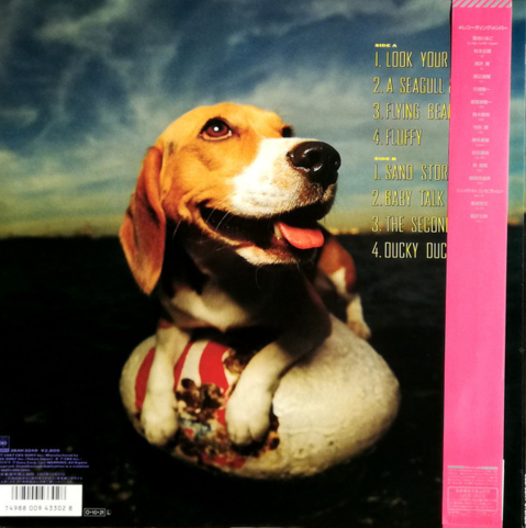 Reverse cover art of album Flying Beagle by Himiko Kikuchi. It shows a beagle sitting on what looks like a white, football-shaped buoy with a red logo partially obscured by the paws of the dog. The beagle is shows in half-profile turned toward its left and looking upward, with mouth partially open and tongue slightly extended. It appears content. The beagle has white, brown, and black fur. The background shows a dark foreground under a slightly light, partly cloudy sky (either sunset or sunrise, it is unclear).

Text on the right side shows the track listings. Text in the lower-left shows the bar code and other unreadable fine print, in a mix of English and Japanese. 

The right side of the album has an obi strip--"a piece of paper wrapped around the spine of Japanese CDs, DVDs, movies, or books sometimes referred to as a "spine card"." The reverse of this one is dark-pink and lists the track names in Japanese. It is wrapped from bottom-to-top around the outside of the album, is ~5cm thick, and partially obscures the track listings on the right side of the album.