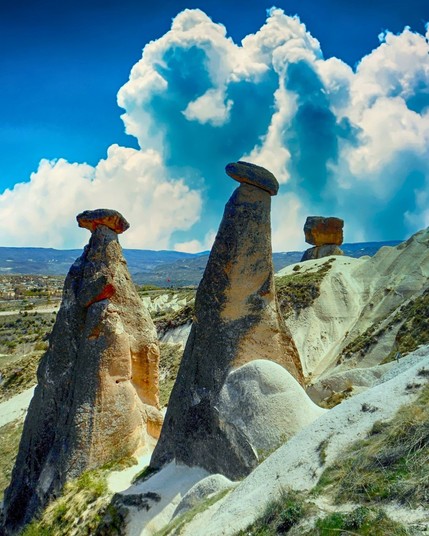 The Three Beauties, black-capped fairy chimneys in Cappadocia, Turkey, symbolize family with father, mother, and child figures, and are the region's most photographed.