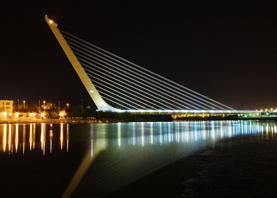 a photo of a harp-shaped bridge, taken at night 