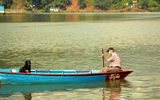 Our respected client is boating at Begnash Lake with his black dog.