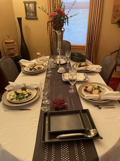 Lovely dinner table setting for thanksgiving.
Center runner, flowers, fresh salad, lovely. 