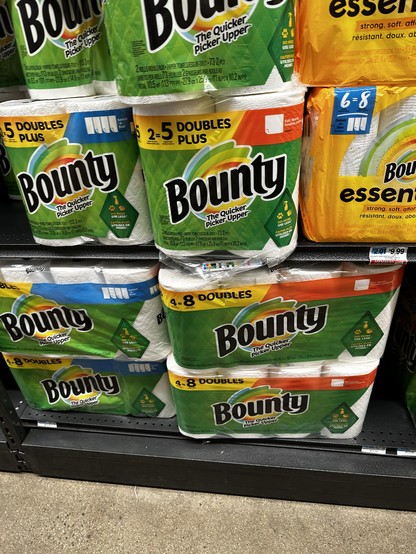 Rolls of paper towels on a store shelf claiming that 4 rolls of paper towels are equal to 8 rolls of paper towels. 