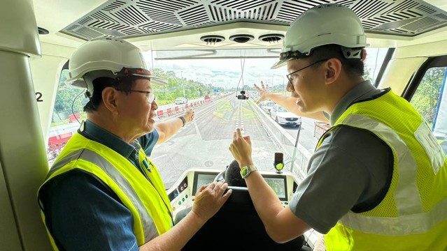 Two people discussing with each other in the driver cab of the ART vehicle. / Photo from linked article.