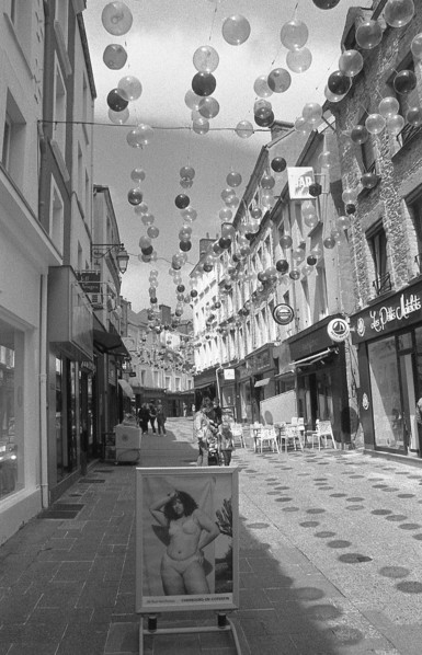 Une rue piétonne couverte de ballons, noir et blanc