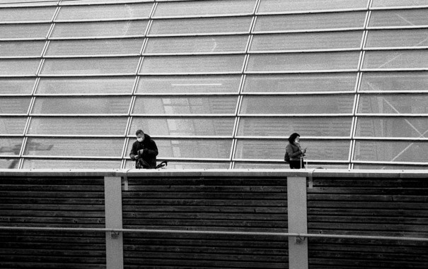 Deux personnes sur le quai de la gare, noir et blanc.