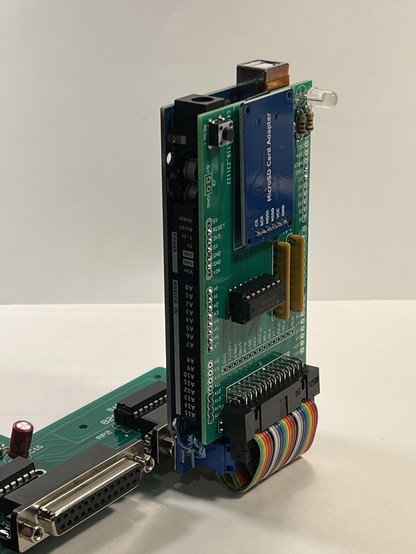 An ArduinoFile plugged into an Apple Lisa motherboard parallel port. The ArduinoFile is sitting up right perpendicular to the motherboard. 