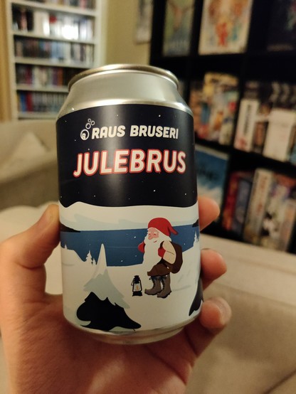 Ein liten brusboks. På etiketten ser vi ei teikning av ein nisse i brune bukser, lys ullgenser, nesnalobbar (ullsko) og stor, raud nisselue. Nissen står og smiler fornøgd i eit vinterlandskap, med snødekte grantre, snødekte fjell og ein fjord som speglar den stjerneklare himmelen i bakgrunnen. Tekst: "Raus Bruseri Julebrus"