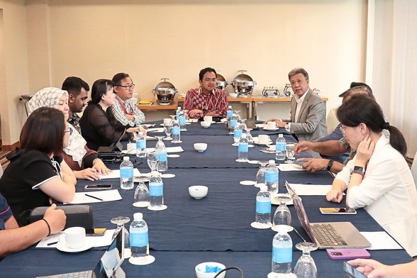A group of people having discussion at a table. / Photo from the linked article.