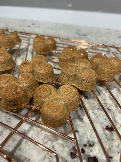 Close up angled view of shortbread biscuits on a cooling rack in the shape of triskels