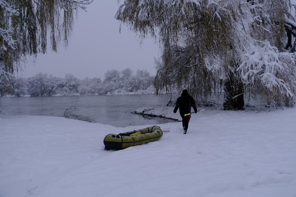 Packraft wird über den Schnee zum Hafenbecken gezogen.