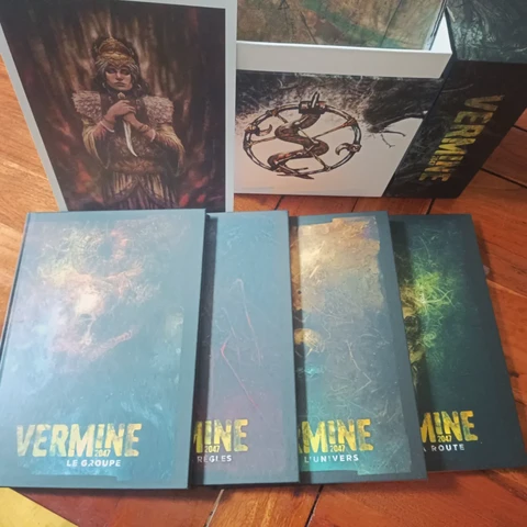 Le triptyque des ouvrages de base et le supplément "La route", la boîte de rangement et une illustration d'une femme tenant un poignard.