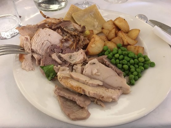 A plate with meat, peas, potatoes 